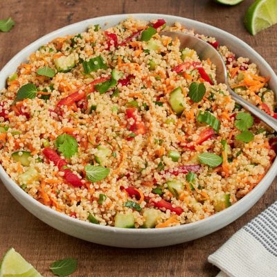 Thai quinoa salad with fresh herbs and lime vinaigrette in a square bowl.