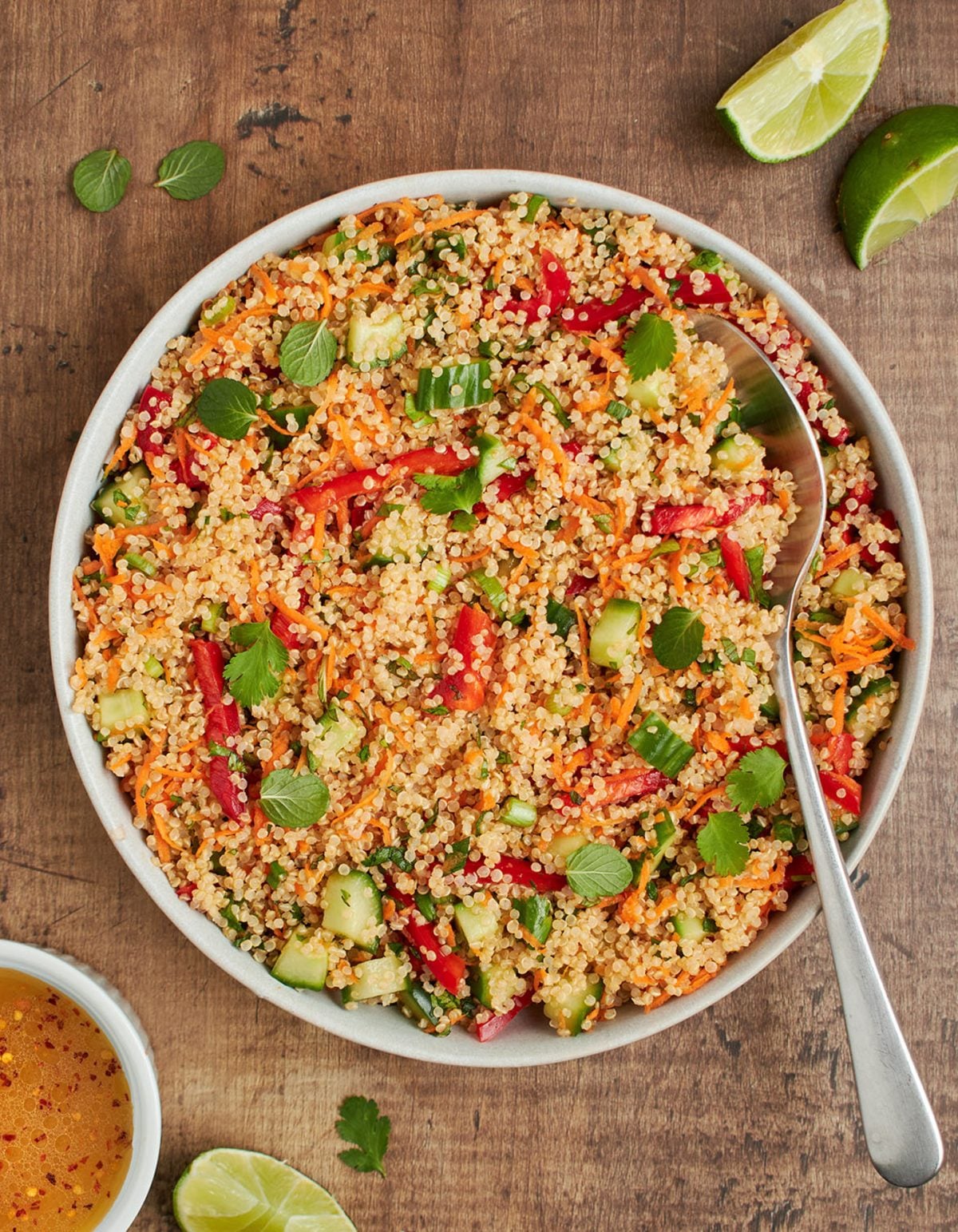 Thai quinoa salad with fresh herbs and lime vinaigrette in a square bowl.