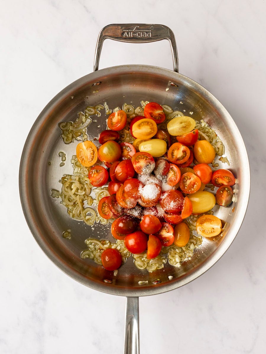 tomatoes, salt and pepper added to shallots and garlic in large pan