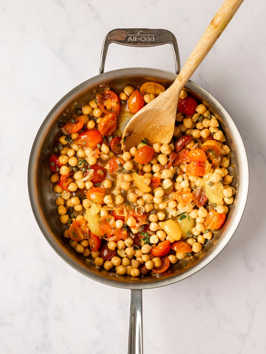 chickpeas, capers, vinegar, and thyme added to large pan with tomatoes, garlic, and shallots