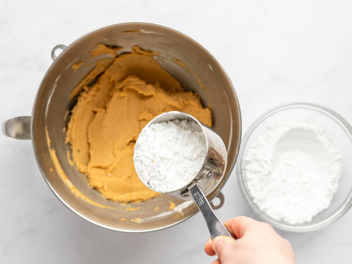 gradually adding the sugar to the peanut butter mixture.