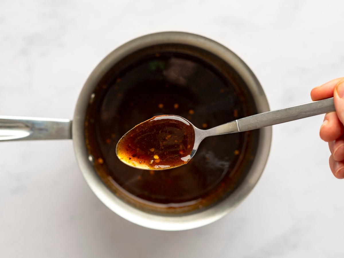 thick glaze on spoon over saucepan.