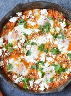 shakshuka in cast iron skillet with linen napkin.