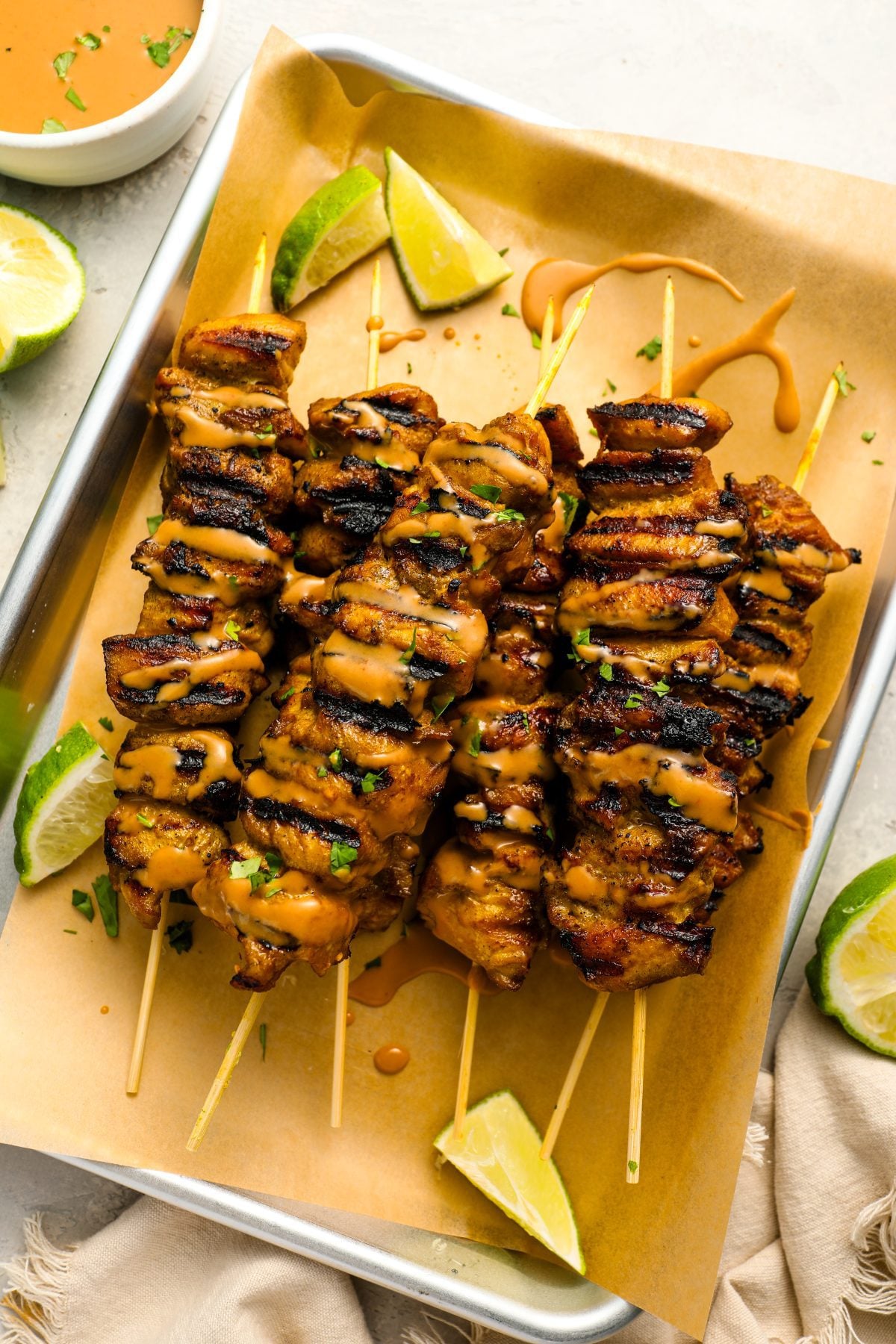 thai grilled chicken with peanut sauce on tray.