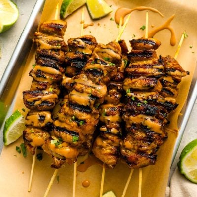 thai grilled chicken with peanut sauce on tray.