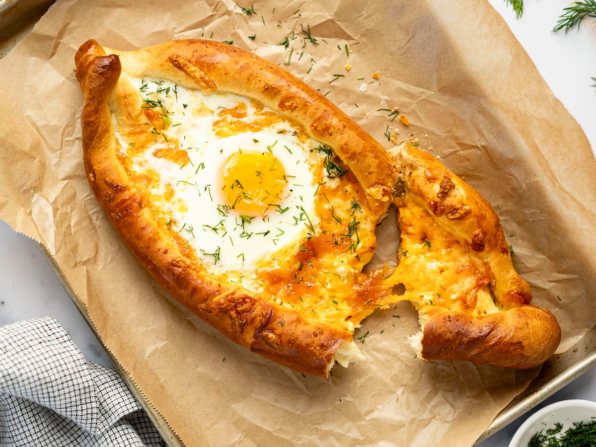 Torn khachapuri on baking sheet