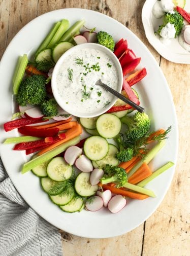 bowl of ranch dressing on platter of vegetables.