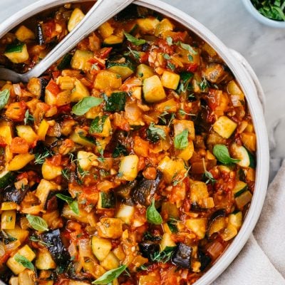 bowl of ratatouille with spoon and white linen napkin