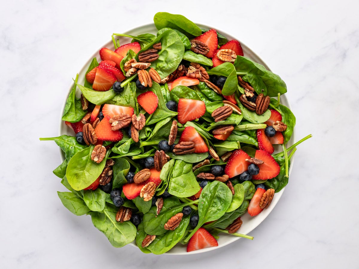 spinach, berries, and pecans in large bowl.