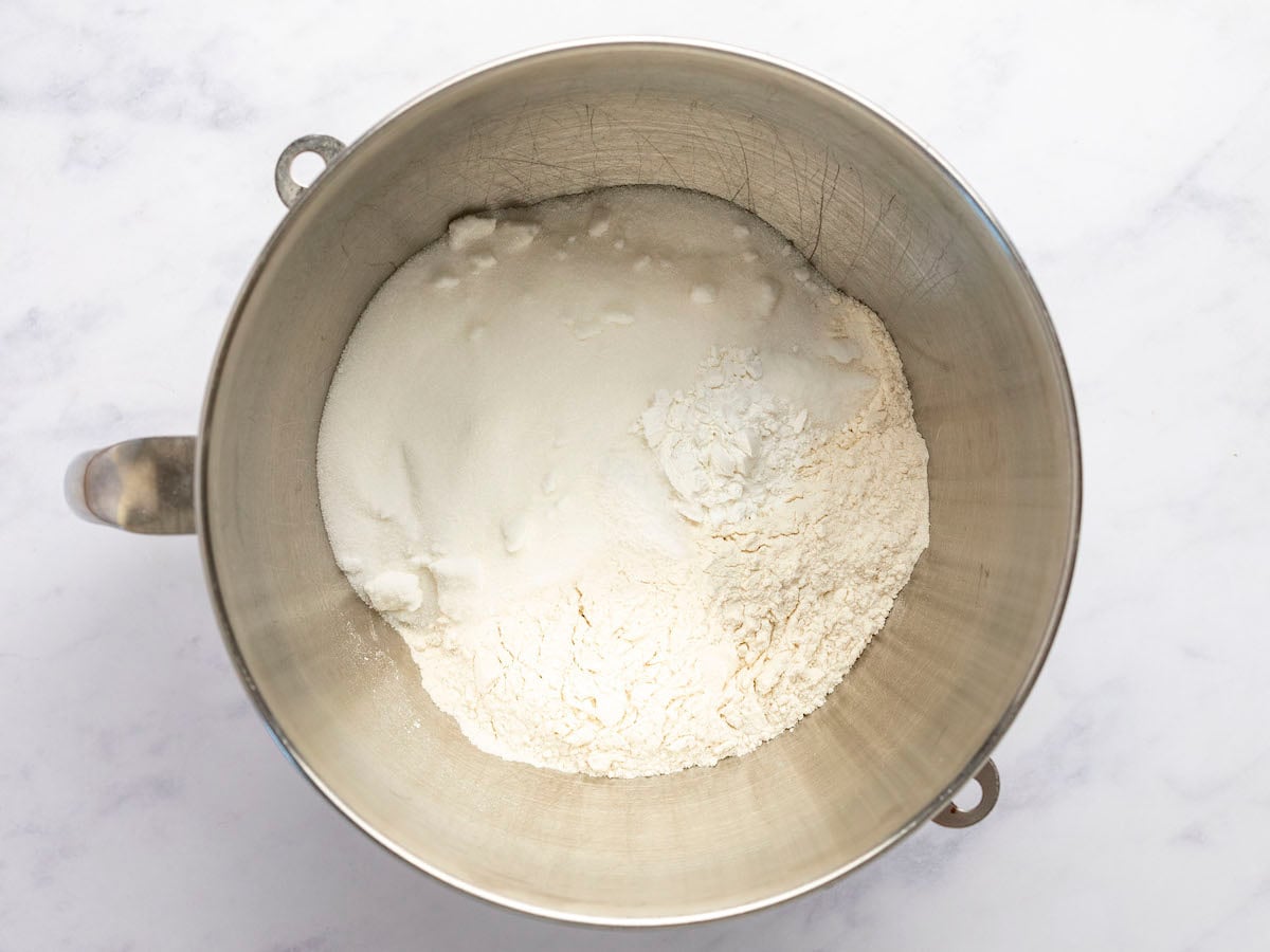 bowl of a stand mixer with flour, sugar, baking powder, and salt