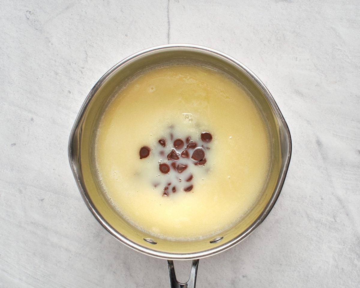 chocolate chips added to heated cream, butter, sugar, and salt in medium saucepan