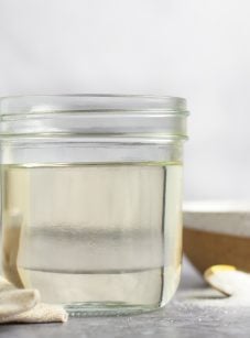 jar of simple syrup with spoon and linen napkin