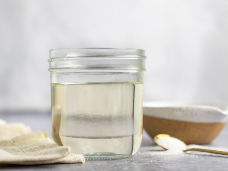 jar of simple syrup with spoon and linen napkin