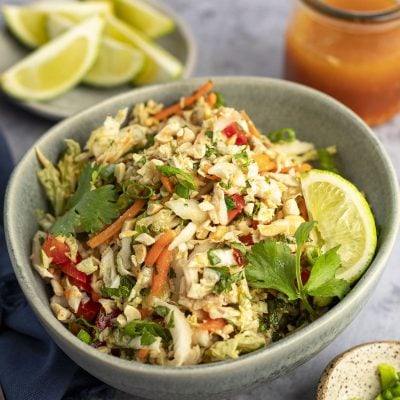 Vietnamese Shredded Chicken Salad in Bowl with Lime Wedges