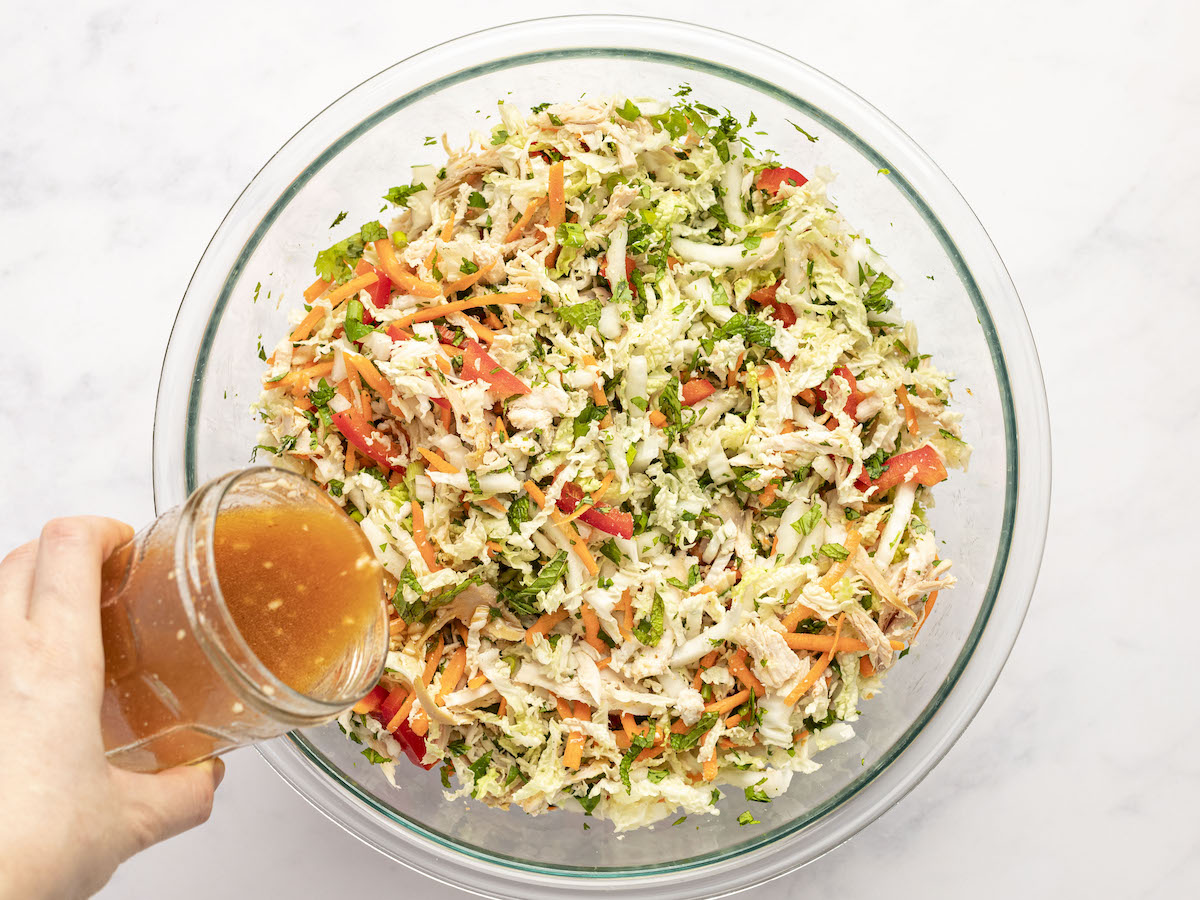 adding dressing to the salad