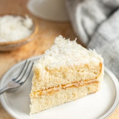 slice of coconut cake on white plate.