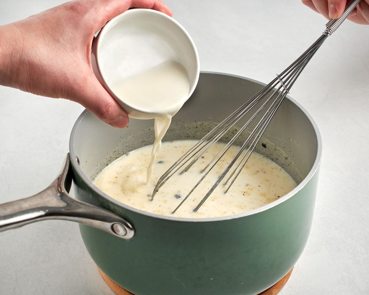milk/cornstarch mixture added to saucepan containing milk, the heavy cream, sugar, corn syrup, salt, and vanilla bean and seeds