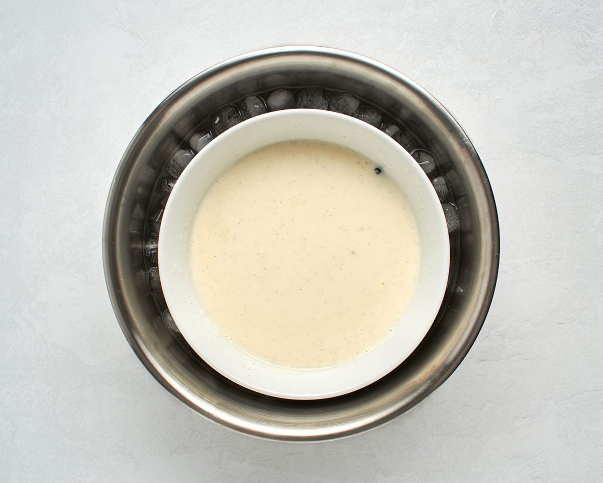 white bowl with ice cream mixture nestled in larger bowl with ice bath