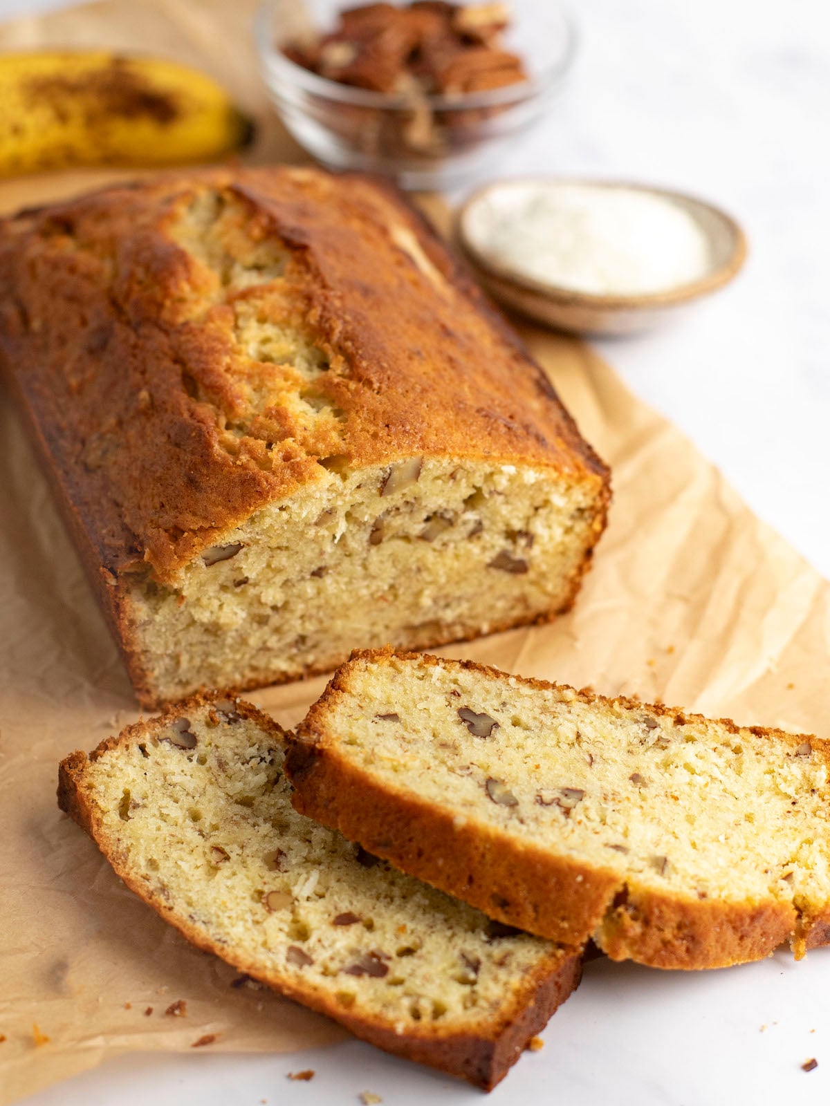 banana bread with coconut and pecans on cutting board