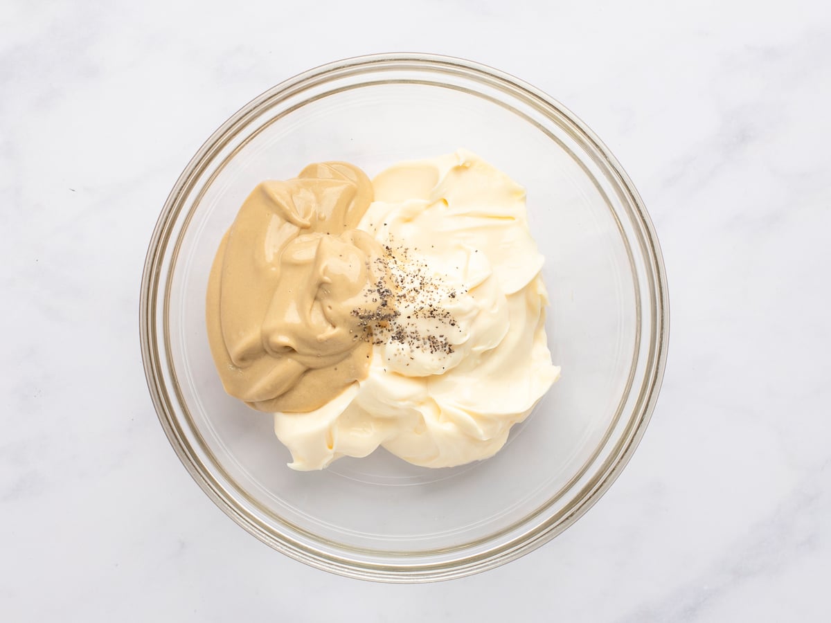 mayonnaise, mustard, and pepper in piles in small glass bowl