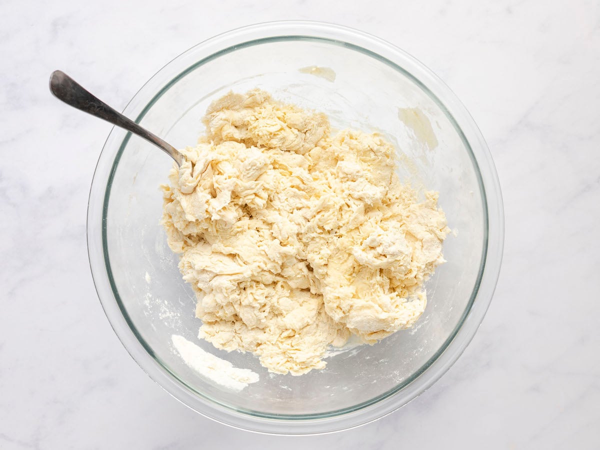 shaggy mass of dough in glass bowl