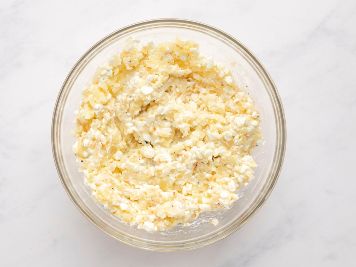 sauteed onions, mashed potatoes, cottage cheese, salt, and pepper combined in large glass bowl