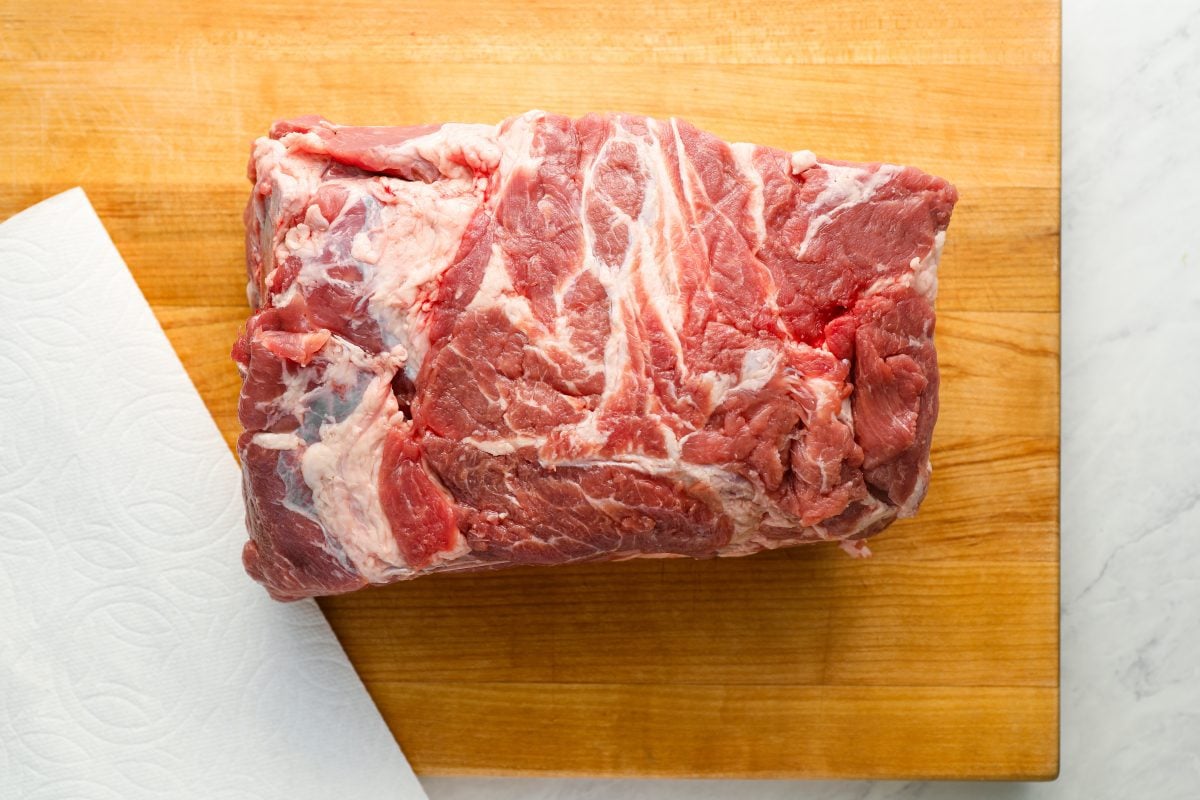 pork butt on cutting board with paper towel