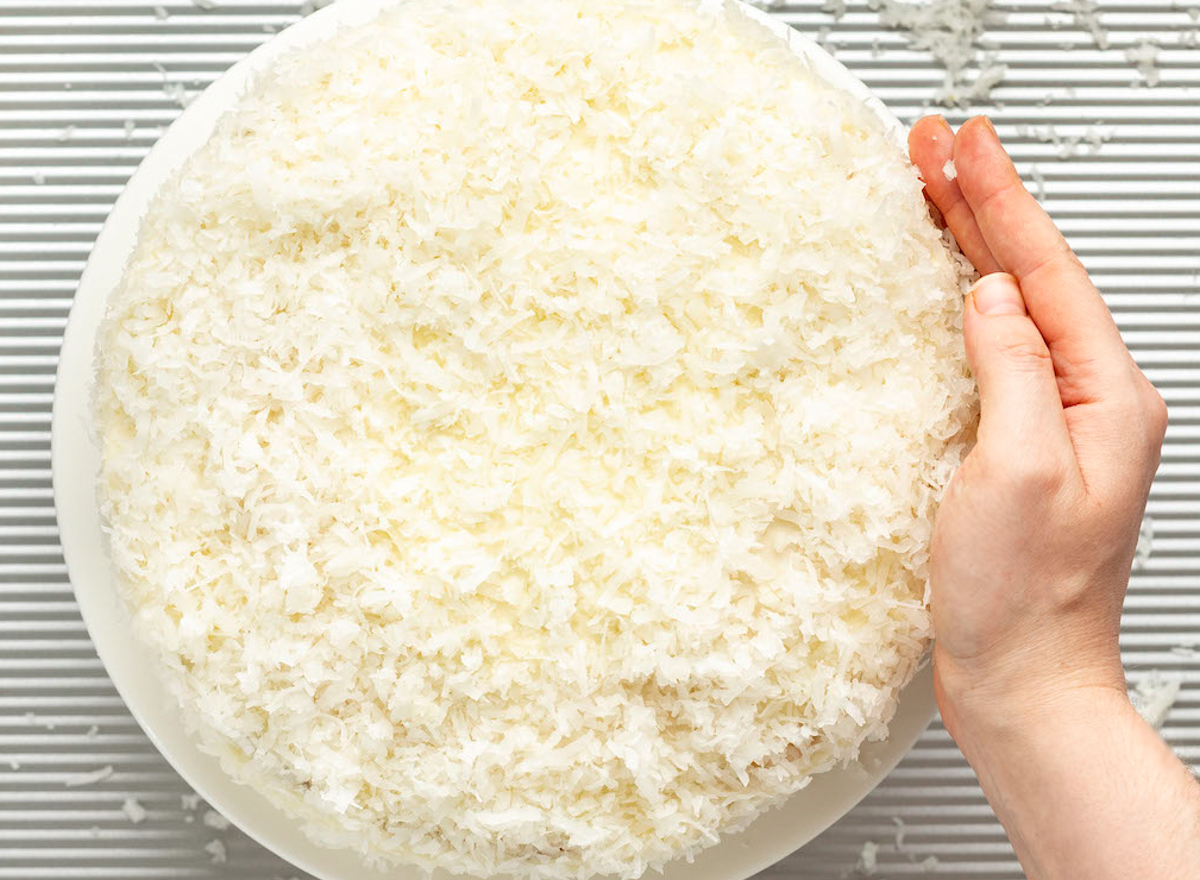 adding layer of coconut to cake