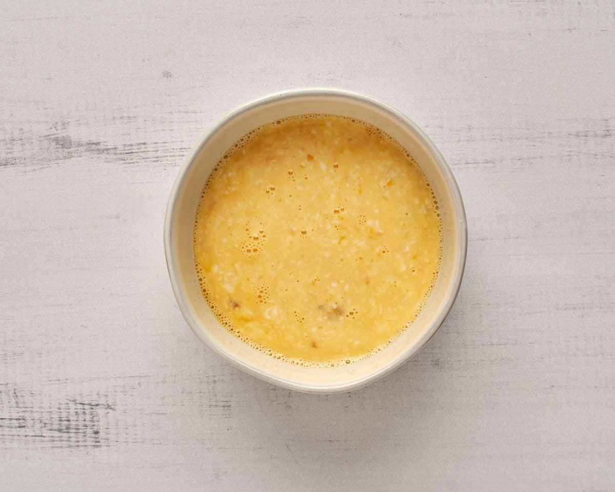 milk/lemon mixture, eggs, vanilla, and lemon zest combined in white bowl