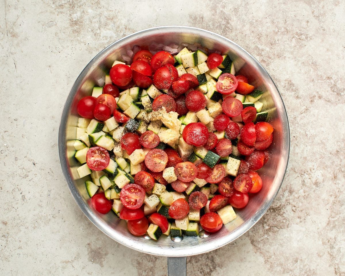 zucchini, tomatoes, garlic, salt and, pepper added to onions in large sauté pan