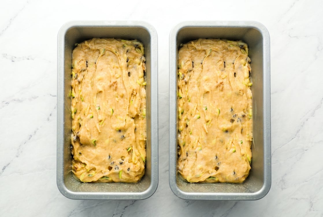 zucchini bread batter in greased loaf pans