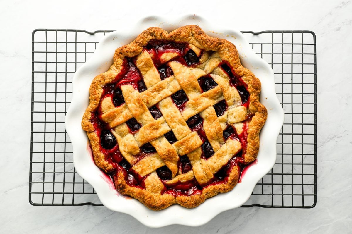 baked cherry pie on metal cooking rack