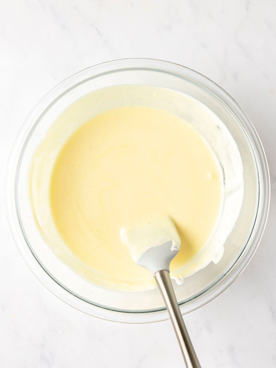 spatula combining whipped egg whites with egg yolk mixture in large bowl