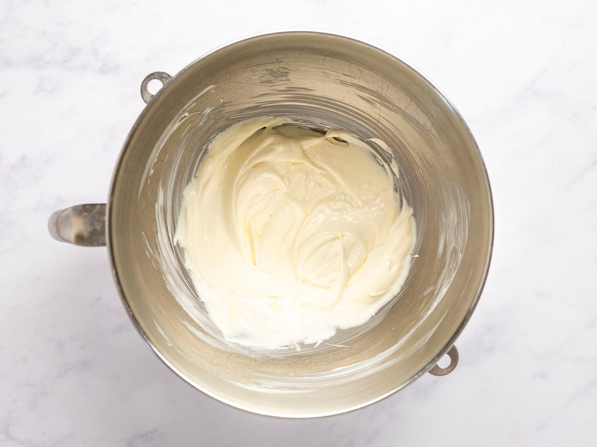 electric mixing bowl with cream cheese, sour cream, mayonnaise, Worcestershire sauce, garlic powder, and sugar combined together