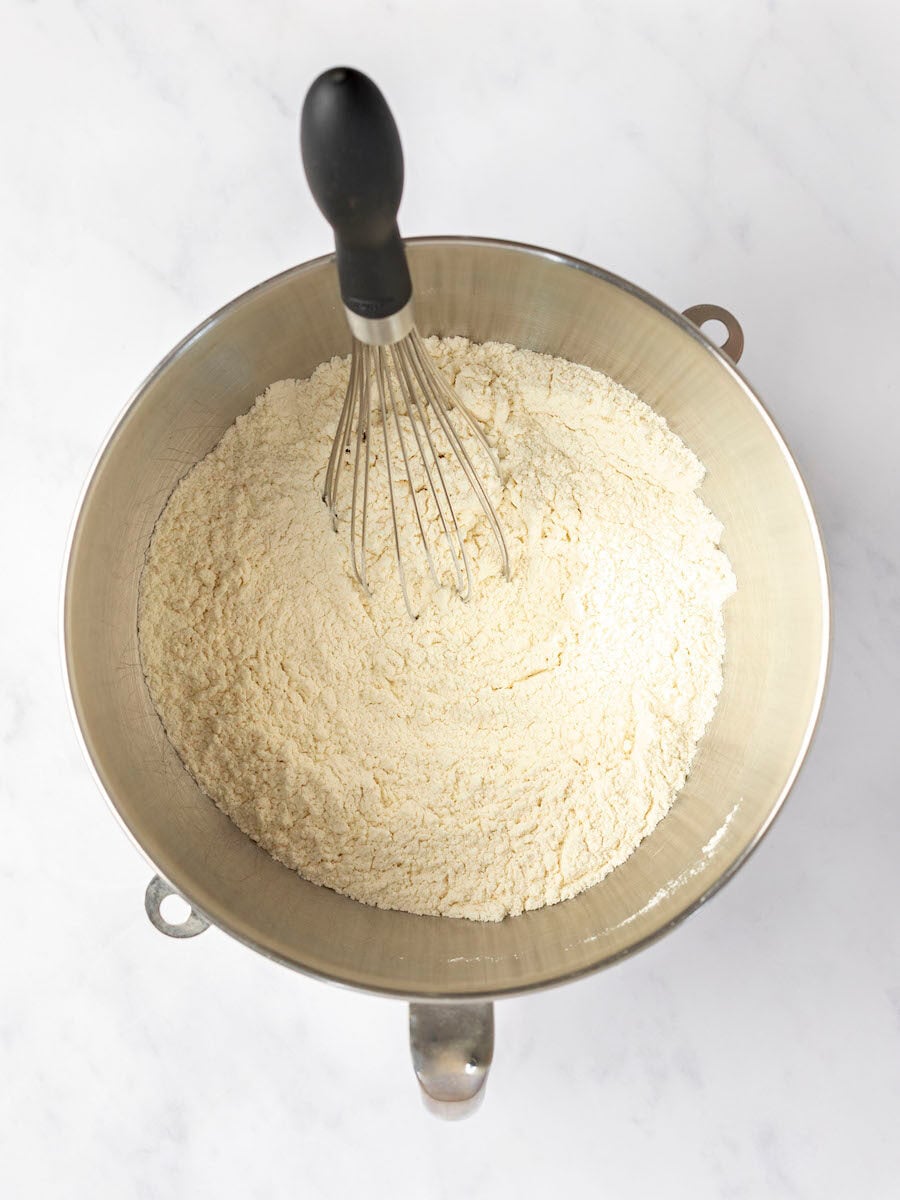 whisk combining flour, yeast, sugar, and salt in large bowl