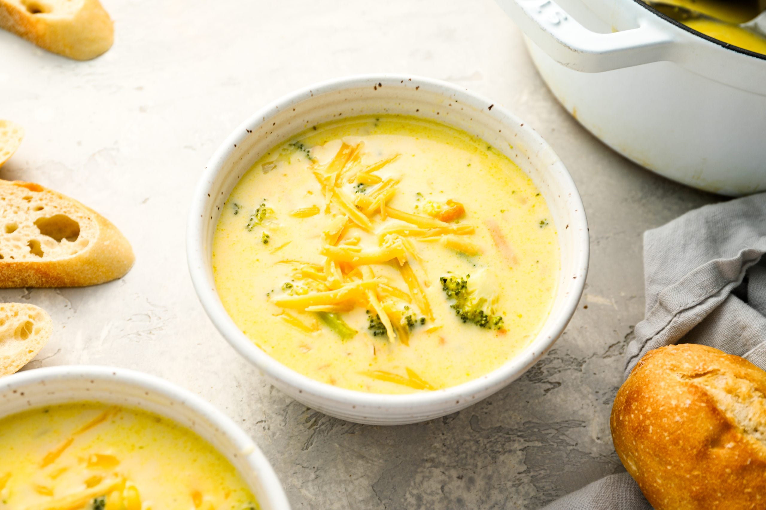 bowls of broccoli cheddar soup topped with cheese