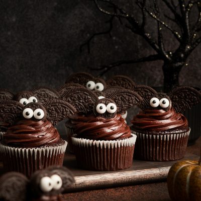 adorable bat cupcakes on cutting board with spooky tree