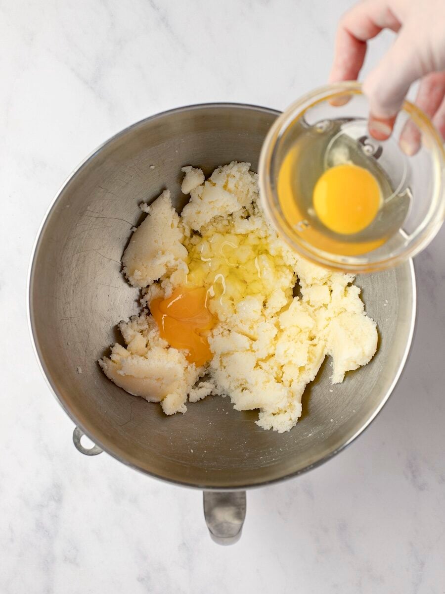 Adding eggs to creamed butter and sugar.