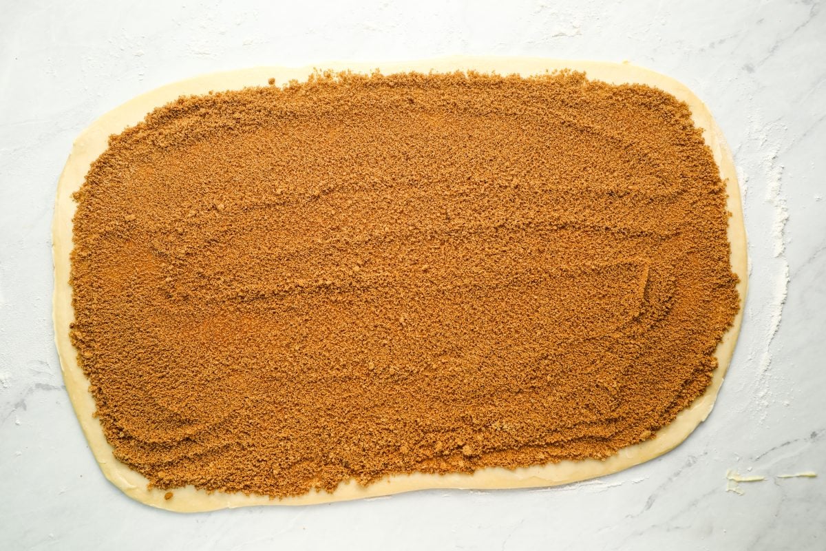 dough rectangle spread with butter and topped with cinnamon sugar mix
