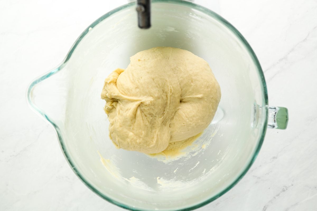 kneaded dough in glass mixing bowl
