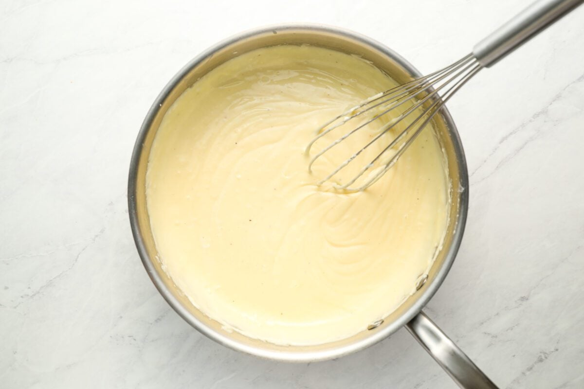 bechamel sauce with whisk in medium saucepan
