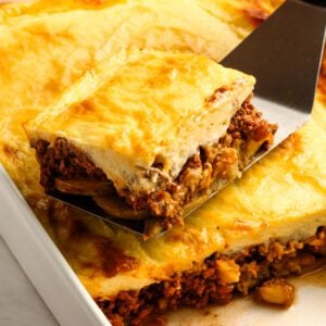 spatula removing portion of moussaka from baking dish