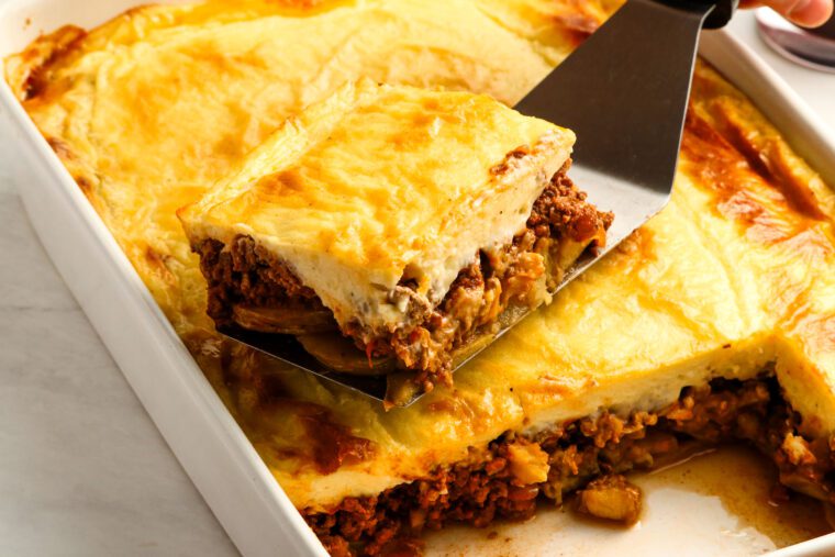 spatula removing portion of moussaka from baking dish