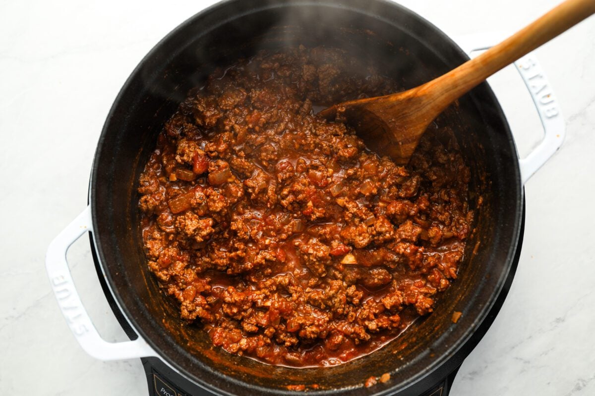browned ground beef, wine, tomatoes in large pot with garlic and onion
