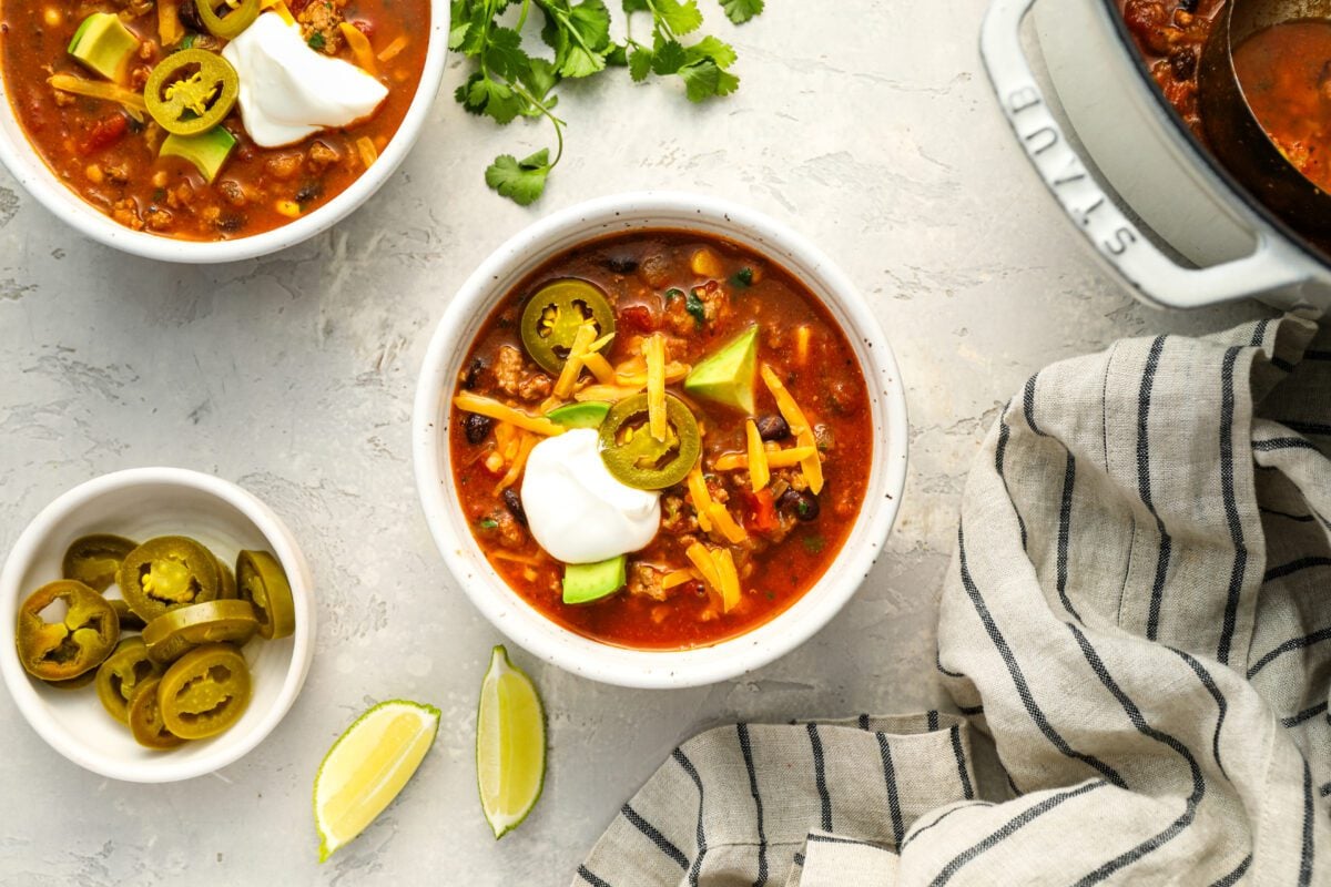 2 bowls of taco soup with garnishes on top