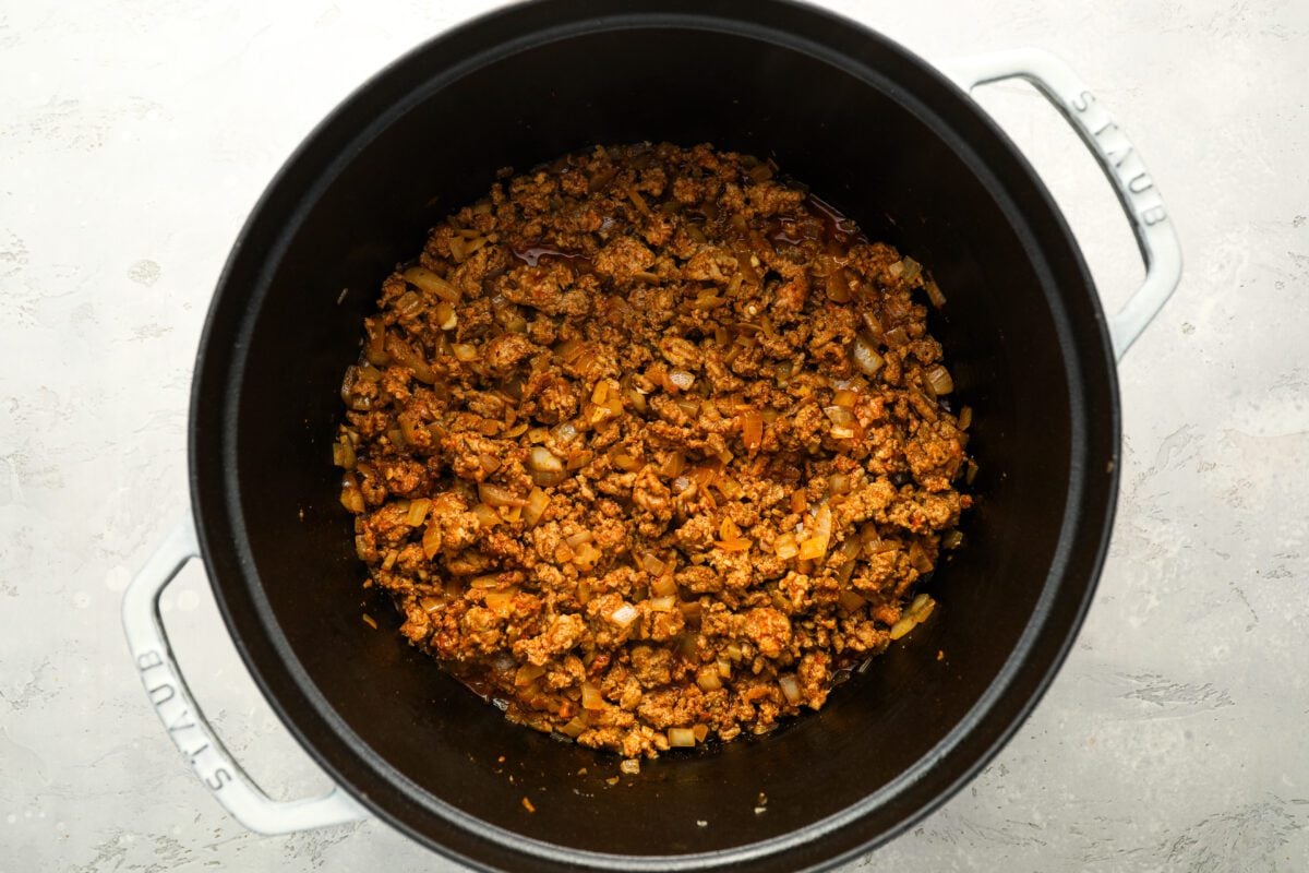 browned ground meat and seasoning in Dutch oven