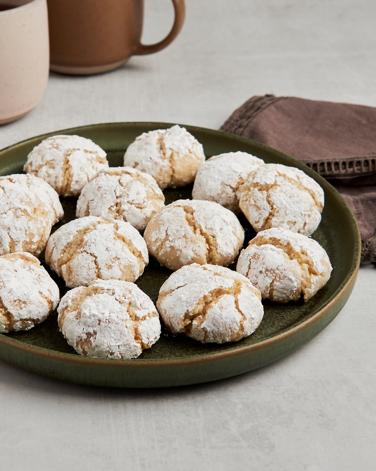 almond cookies on plater with coffee cups.