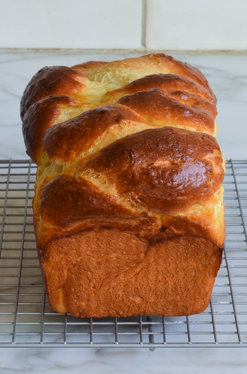 loaf of brioche cooling on rack.