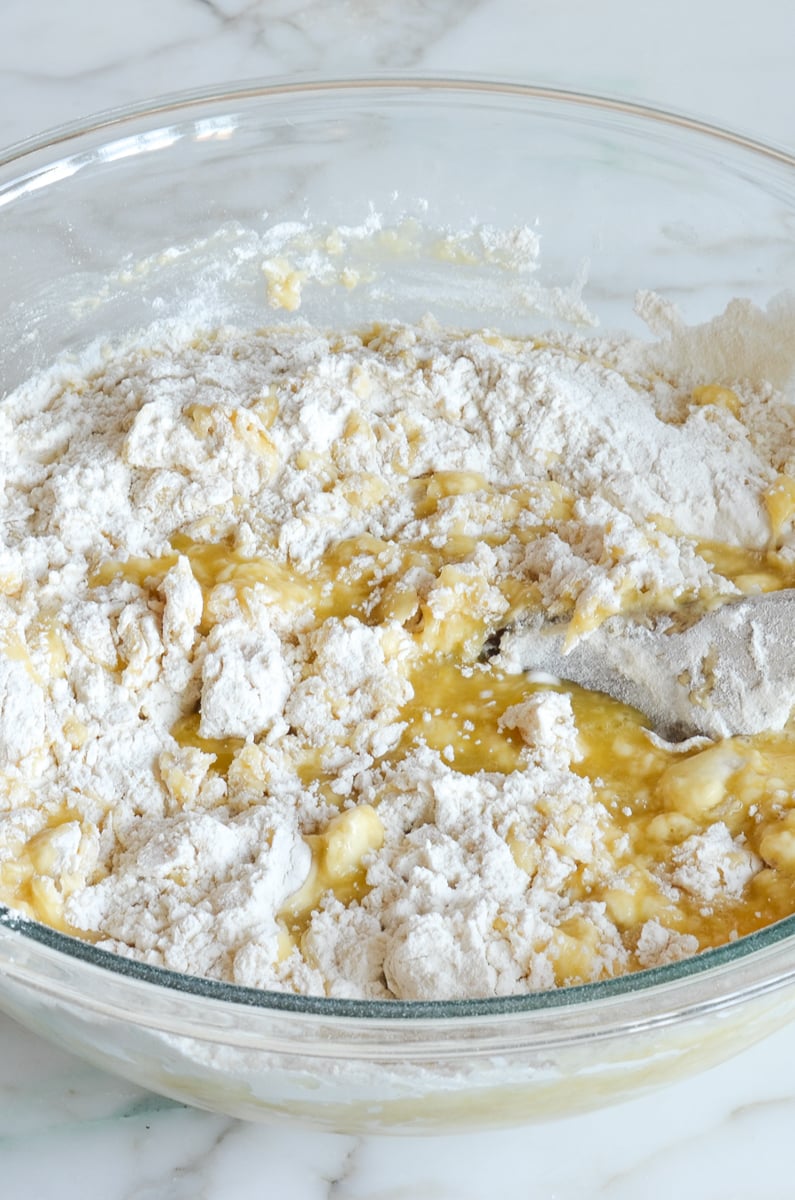 mixing flour into liquid ingredients in mixing bowl.