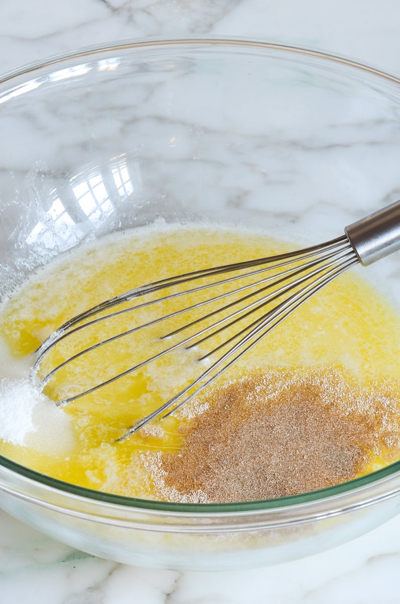 melted butter, sugar, yeast, warm water in mixing bowl with whisk.